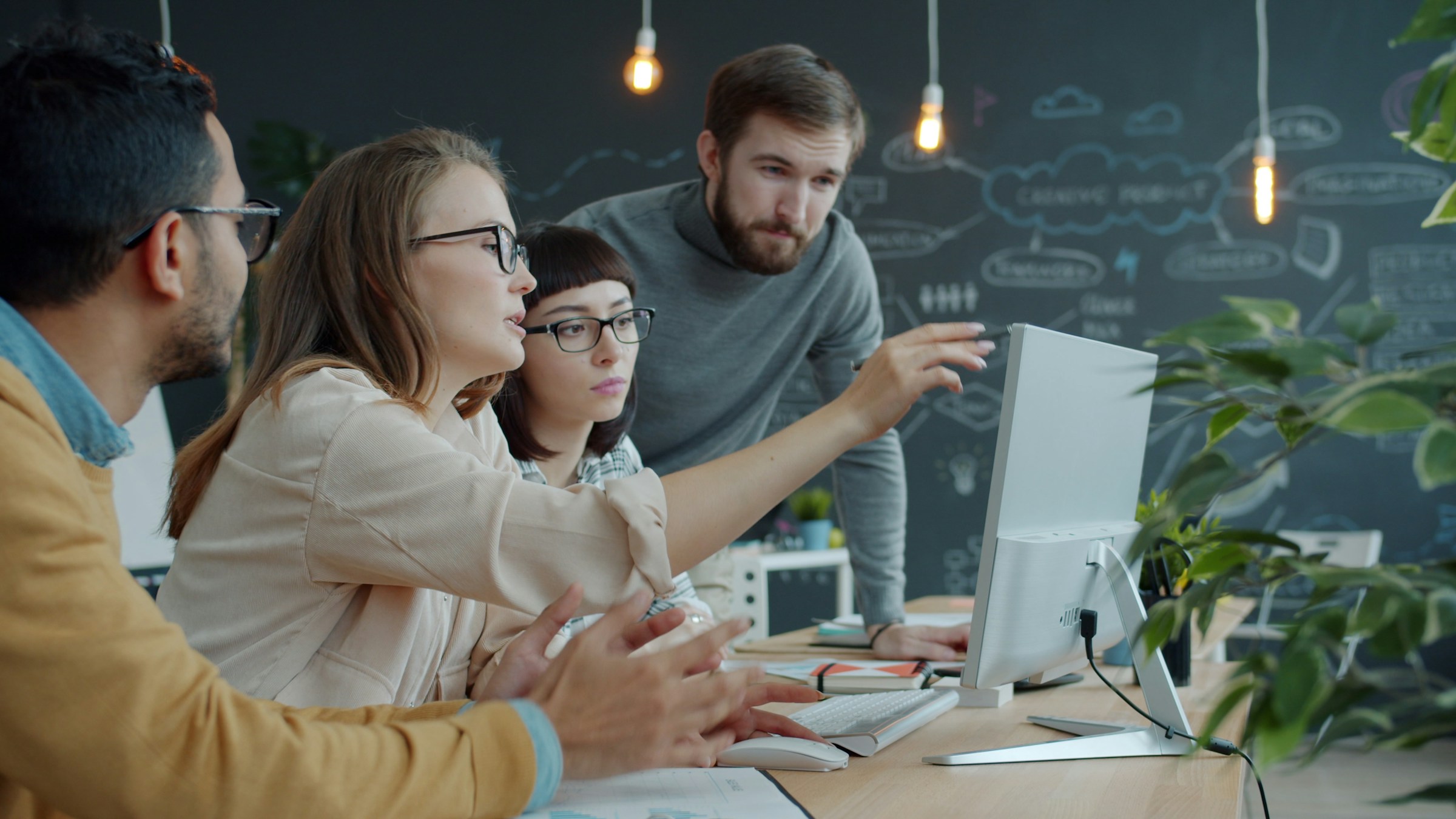 Software professionals collaborating around computers in a modern office